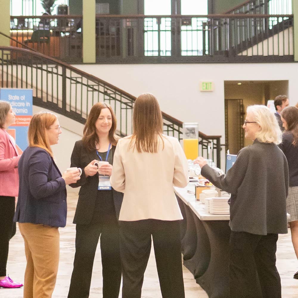 Photo of attendees networking together in the hotel lobby of the 2026 California Medicare Convening.